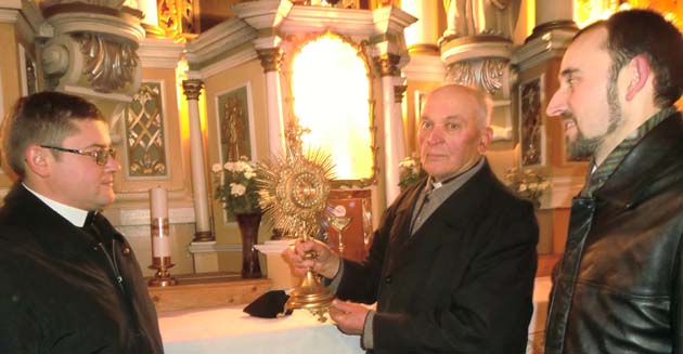 Daugailių Šv. Antano Paduviečio bažnyčioje. Monsinjoras P. Baltuška (viduryje) rodo svečiams ukrainiečiams arkivyskupo Mečislovo Reinio bažnyčiai padovanotą monstranciją. Kairėje – kun. t Anastasijus Kabal OSBM, dešinėje – kun. t. Augustinas Zapotočnyj OSBM. Daugailiai, 2010 m. lapkričio 17 d.